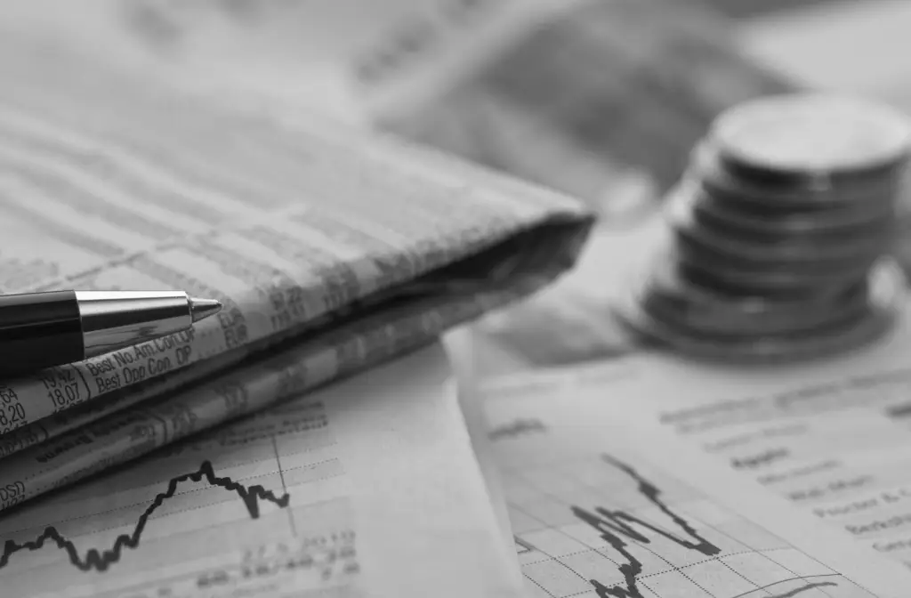 Financial news data spread on analyst desk — news monitoring gap for investment teams
