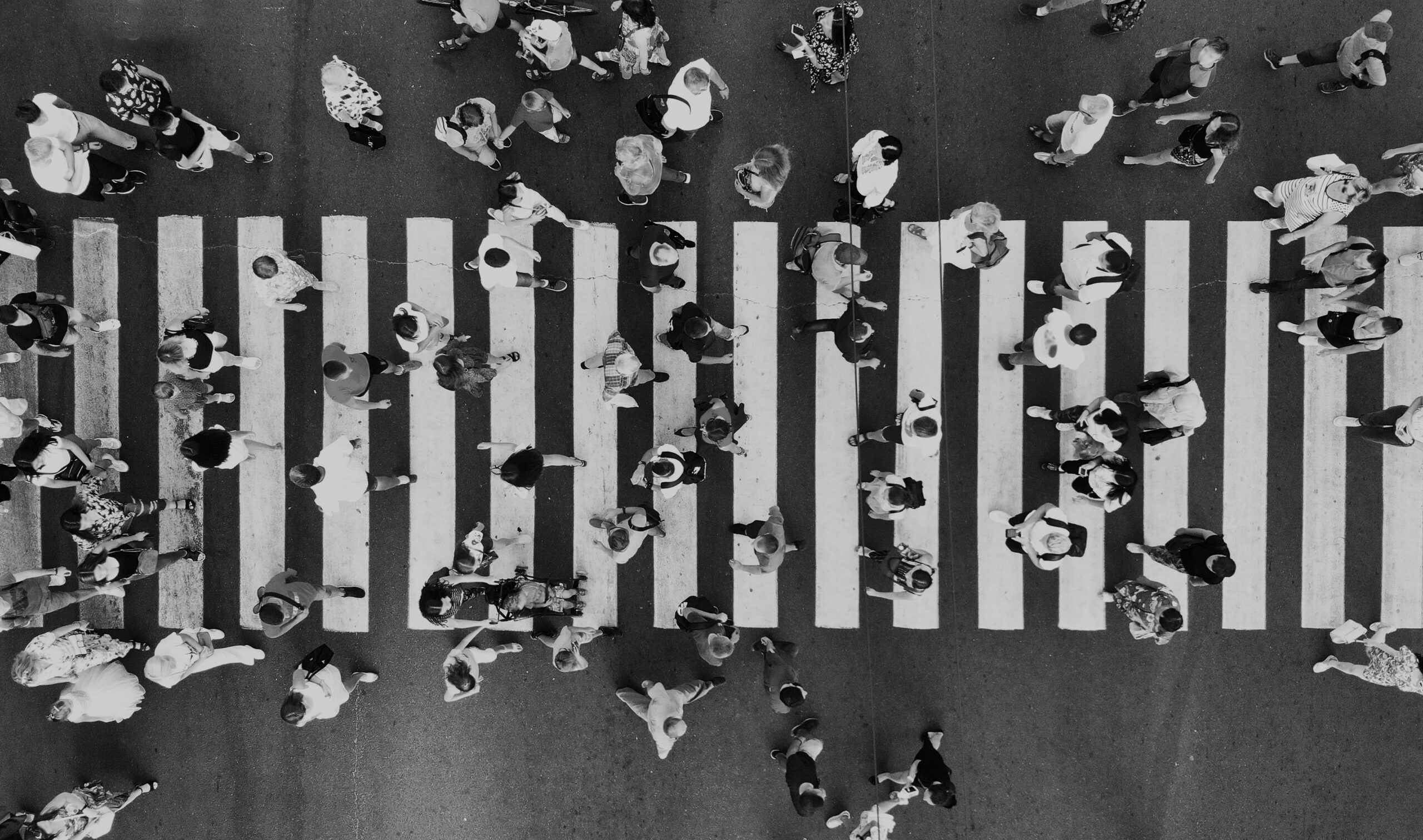 Many people walking across a crossroad, to illustrate feeds.