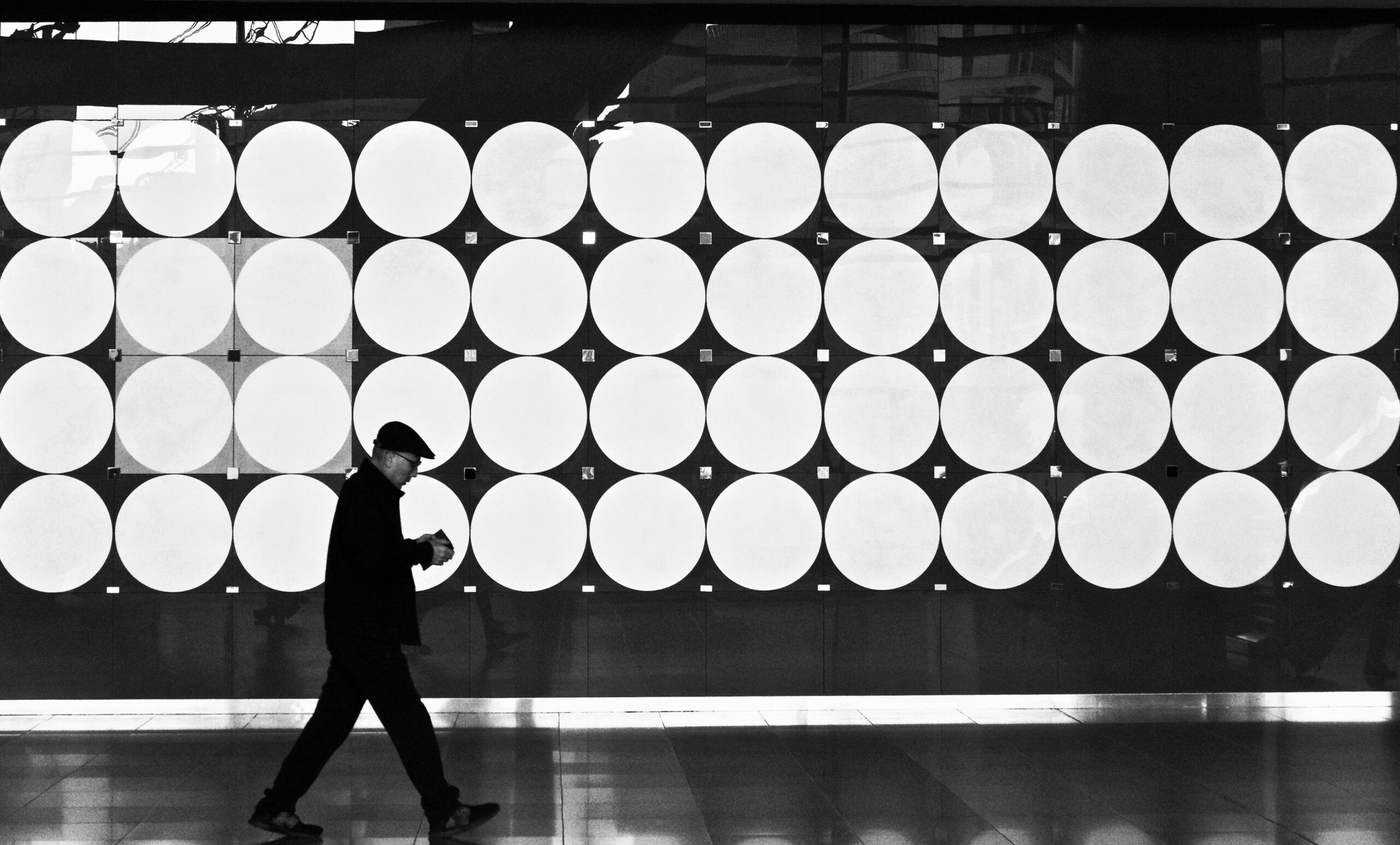 Man walking in front of a wall of round lights, used on the page called Service Packages.